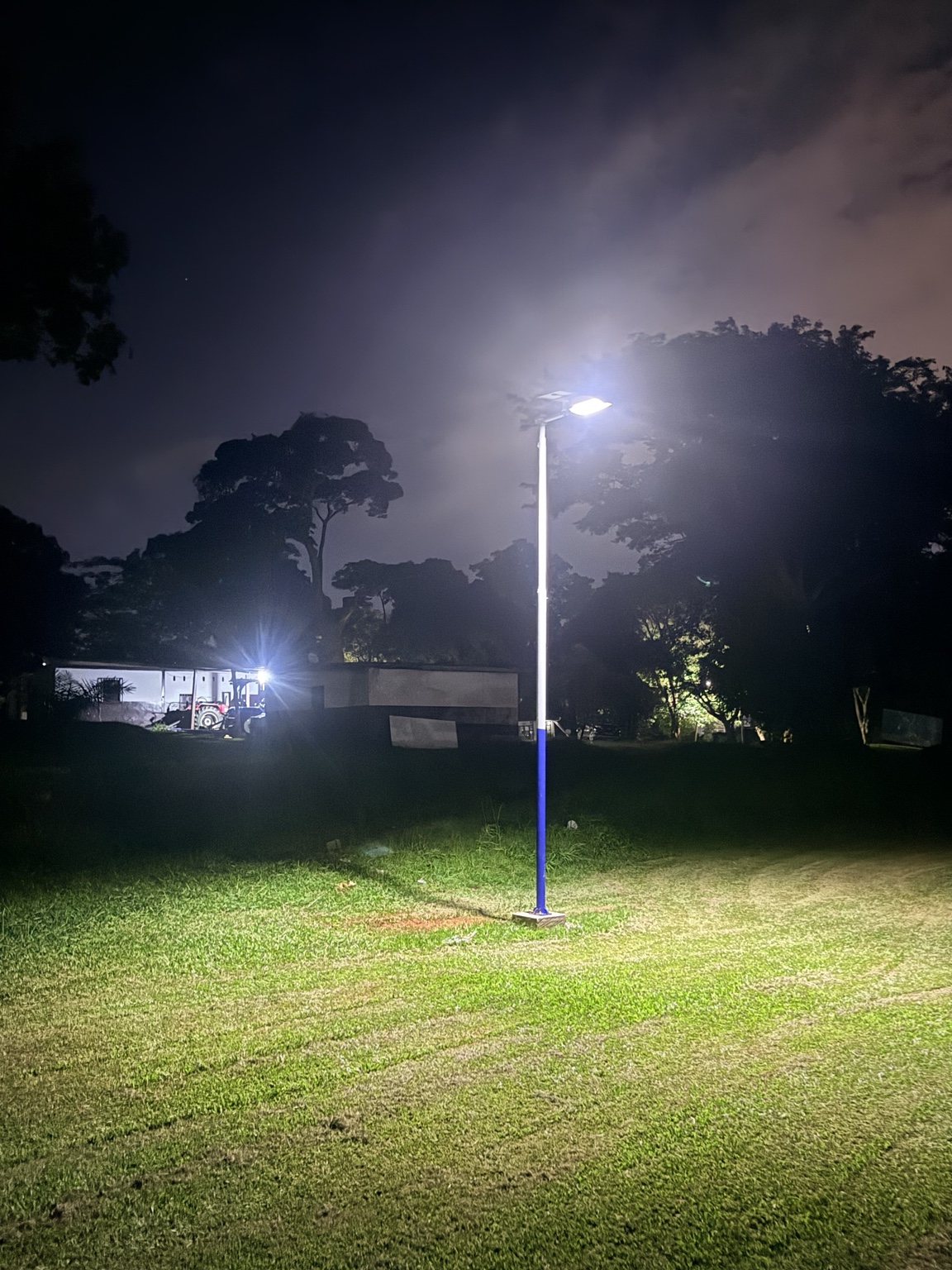 Un poteau solaire déjà installé éclaire une partie du terrain en soirée